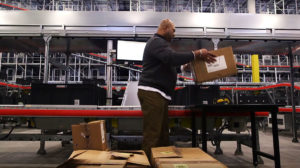 A Walmart employee packages items in their shipping facility.