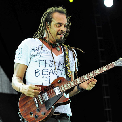 Michael Franti plays guitar on stage