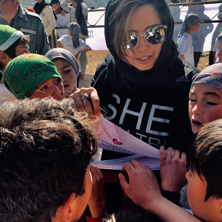 Zeinab Rezaie volunteering at a race surrounded by children 
