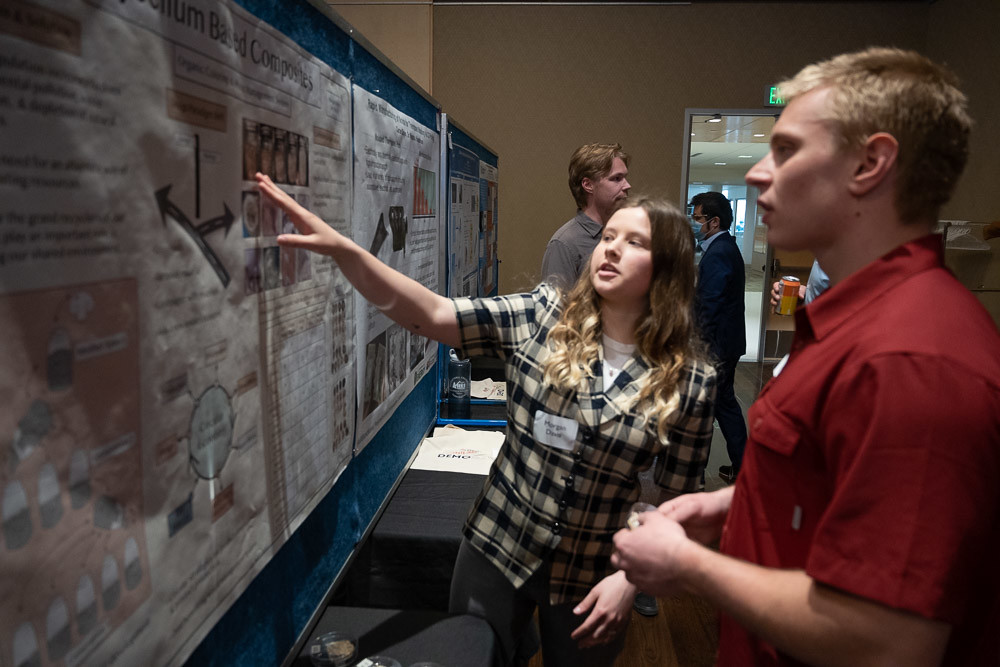 Students look at posters during Demo Day